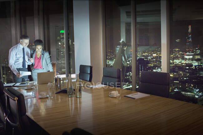 Деловые люди за ноутбуком в конференц-зале ночью — стоковое фото