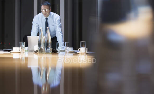 Бизнесмен опирается на стол в конференц-зале — стоковое фото
