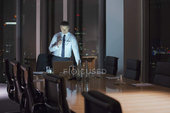 Бізнесмен працює в ноутбуці в конференц-залі вночі — стокове фото