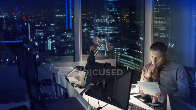 Empresário trabalhando até tarde no computador no escritório — Fotografia de Stock