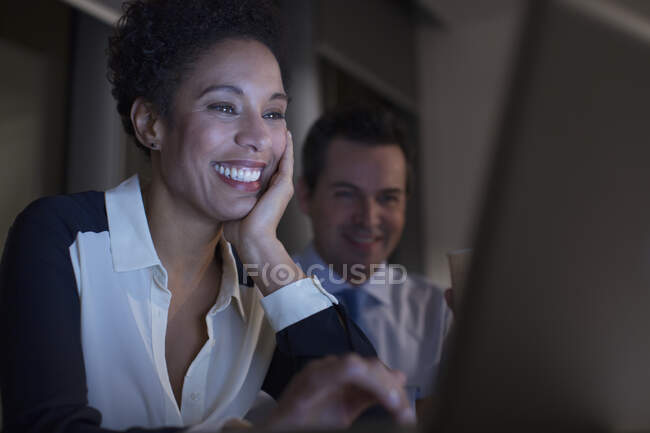 Усміхнені ділові люди, які працюють на ноутбуці. — стокове фото
