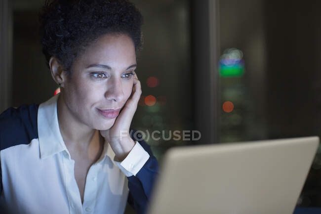 Сфокусована бізнес-жінка працює пізно в ноутбуці — стокове фото