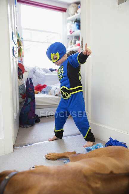 Мальчик в костюме супергероя играет дома — стоковое фото