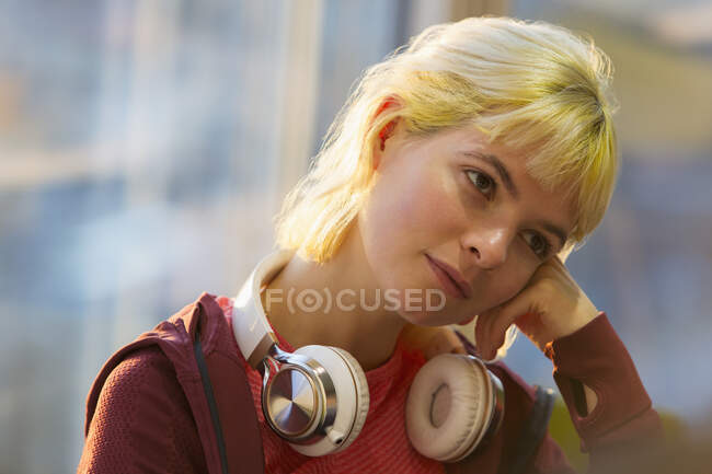 Nachdenkliche junge Frau mit Kopfhörern — Stockfoto