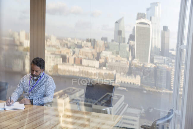 Businessman working in urban highrise conference room, London, UK — Stock Photo