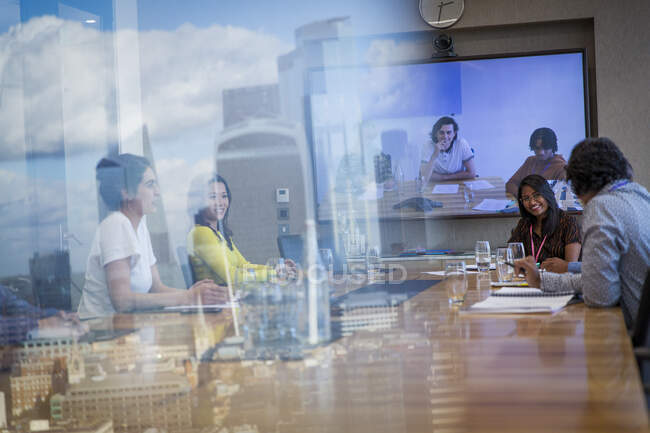 Des gens d'affaires par vidéoconférence dans une salle de conférence urbaine — Photo de stock
