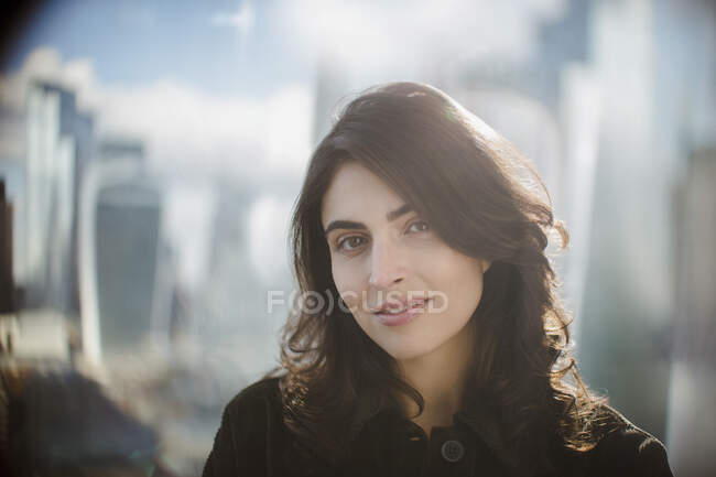 Retrato mujer de negocios confiada en ventana soleada - foto de stock