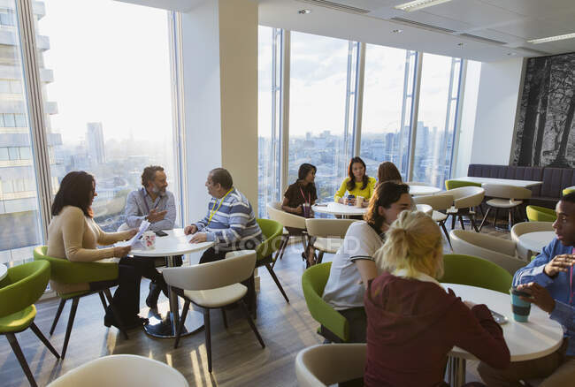 Business people meeting and eating lunch in highrise cafeteria — Stock Photo