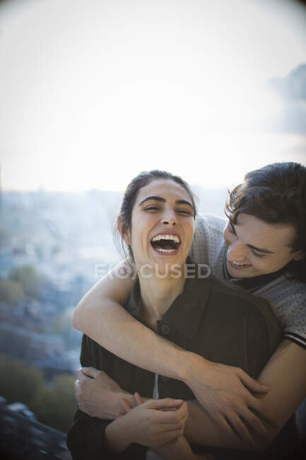 Feliz jovem casal rindo e abraçando na varanda — Fotografia de Stock