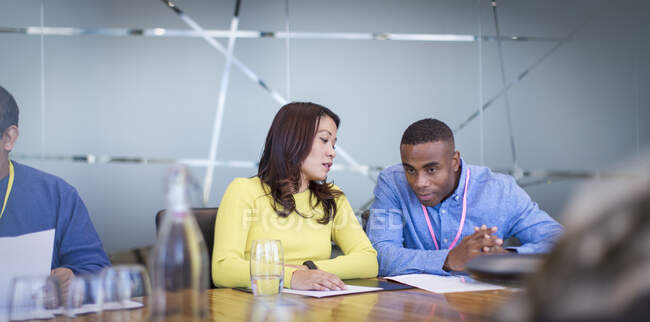 Empresários discutindo papelada em reunião de sala de conferências — Fotografia de Stock