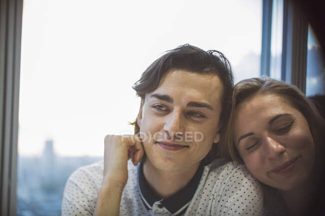 Affectionate young couple in window — Stock Photo