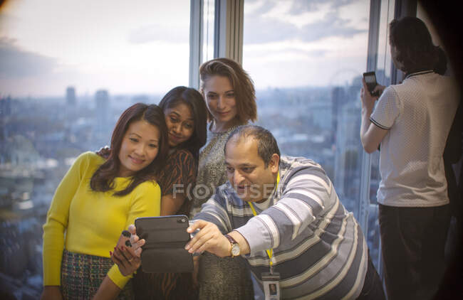 Business people taking selfie at highrise office window — Stock Photo
