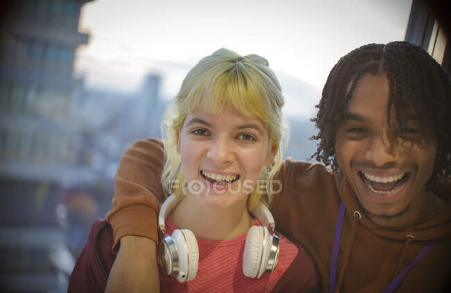 Portrait happy young couple laughing at window — Stock Photo