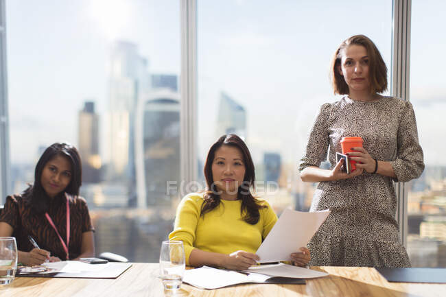 Portrait confident businesswomen in highrise conference room meeting — Stock Photo
