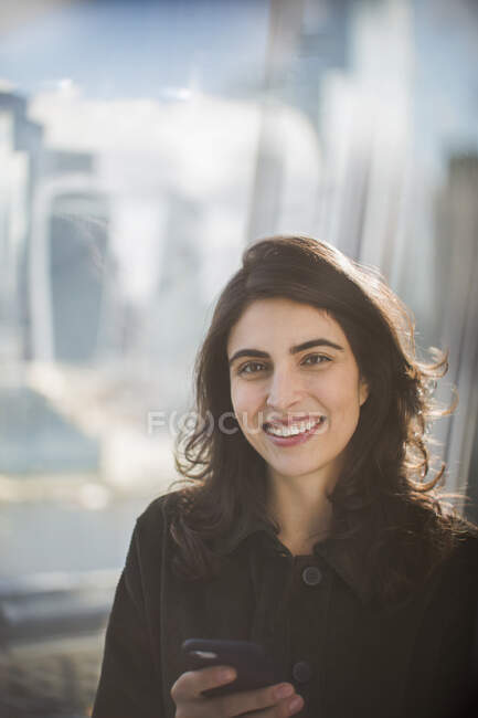 Portrait confident smiling businesswoman with smart phone — Stock Photo
