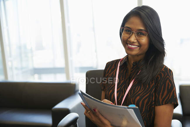 Portrait smiling businesswoman with paperwork — Stock Photo