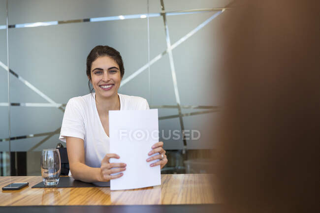 Ritratto fiduciosa donna d'affari sorridente con scartoffie in riunione — Foto stock