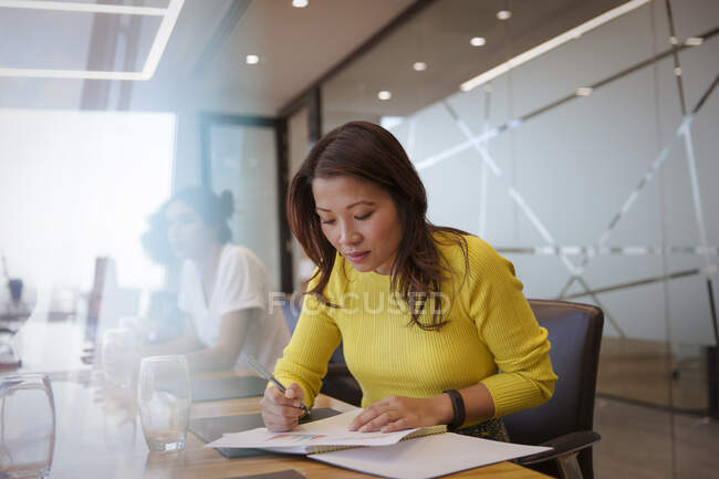 Empresária com papelada em reunião de sala de conferências — Fotografia de Stock