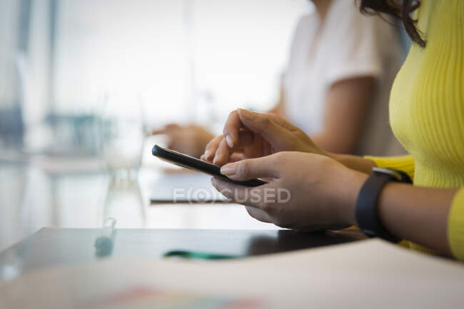 Close up donna d'affari utilizzando lo smart phone in riunione — Foto stock