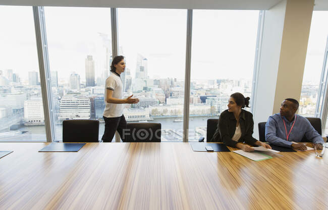 Businessman talking at highrise conference room window, London, UK — Stock Photo