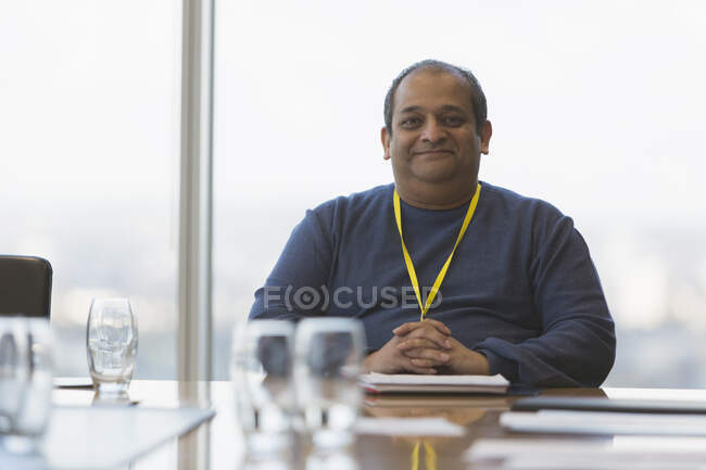 Portrait confident smiling businessman in conference room — Stock Photo