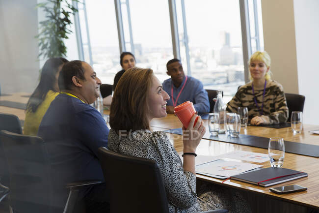 Sorrindo empresária beber café na reunião da sala de conferências — Fotografia de Stock