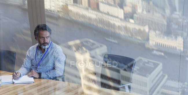Pensativo hombre de negocios que trabaja en la sala de conferencias - foto de stock