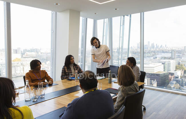 Empresario dirigiendo reunión de sala de conferencias en oficina de rascacielos - foto de stock