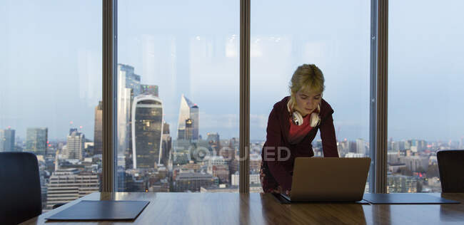 Femme d'affaires utilisant un ordinateur portable dans un bureau de grande hauteur, Londres, Royaume-Uni — Photo de stock