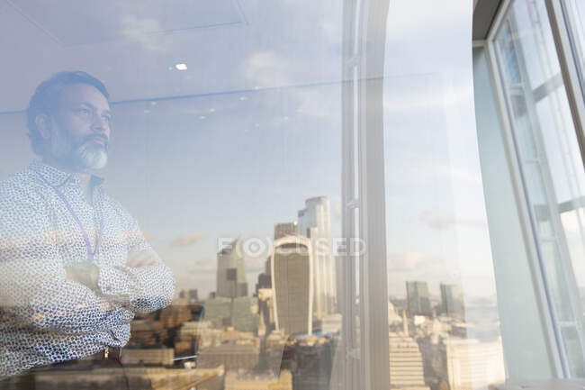 Un uomo d'affari premuroso che guarda fuori dalla finestra del grattacielo, Londra, Regno Unito — Foto stock