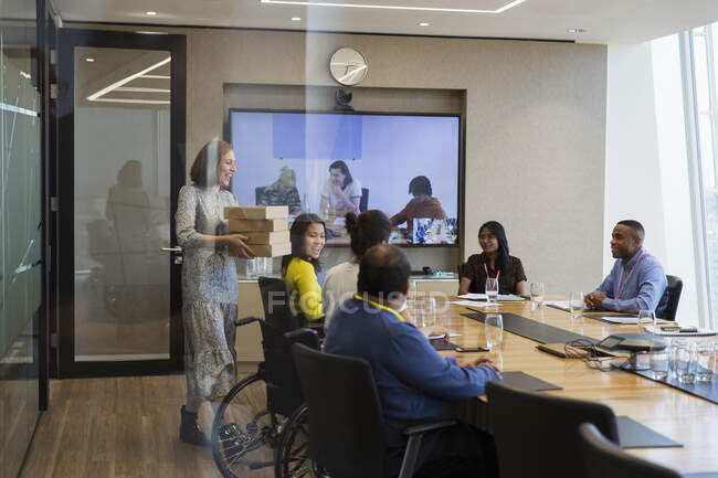 Empresária trazendo almoço para colegas em reunião de sala de conferências — Fotografia de Stock