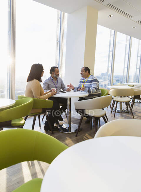 Geschäftsleute unterhalten sich in sonniger Büro-Cafeteria — Stockfoto