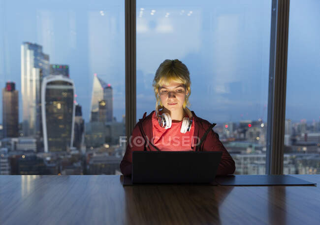 Безробітна жінка, яка працює до пізньої години на ноутбуці у високогірному офісі (Лондон, Велика Британія). — стокове фото