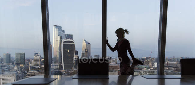 Geschäftsfrau streckt sich am Fenster eines Hochhauses in London, Großbritannien — Stockfoto