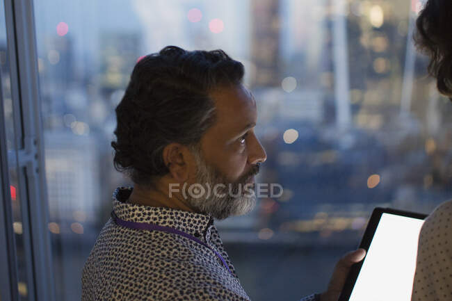 Geschäftsmann mit digitalem Tablet arbeitet spät im Büro, London, Großbritannien — Stockfoto