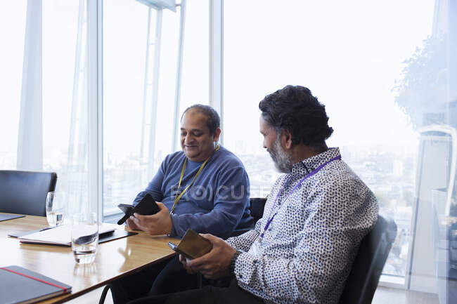 Businessmen using smart phones in conference room meeting — Stock Photo