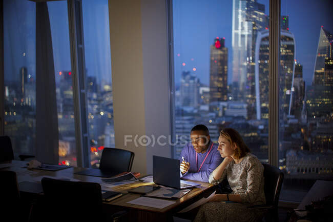 Бізнесмени, які працюють пізно на ноутбуці у високогірному офісі (Лондон, Велика Британія). — стокове фото