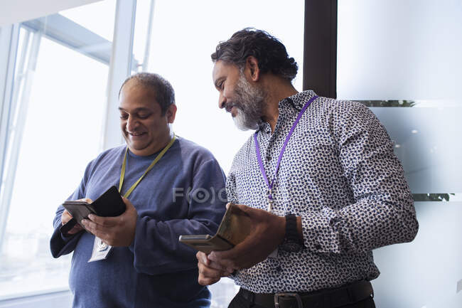Hommes d'affaires utilisant des téléphones intelligents au bureau — Photo de stock