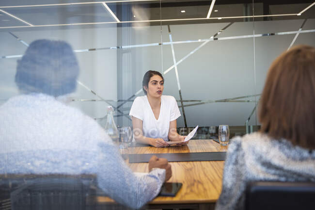 Empresária discutindo papelada em reunião de sala de conferência — Fotografia de Stock