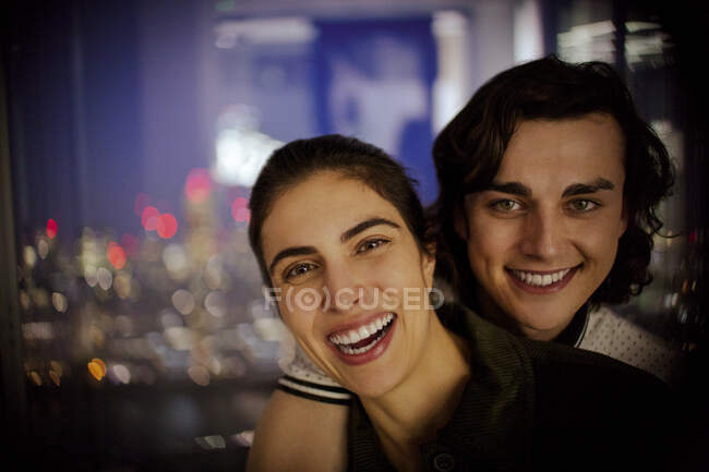 Portrait happy young couple at window — Stock Photo