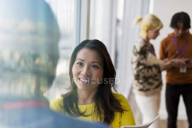 Donna d'affari sorridente che parla con un collega in carica — Foto stock