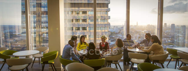 Reunión de empresarios en cafetería urbana de oficinas de gran altura - foto de stock
