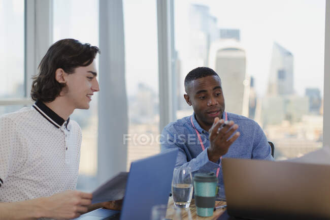 Бизнесмены разговаривают за ноутбуками в конференц-зале — стоковое фото