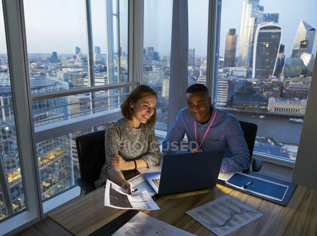 Бизнесмены, работающие за ноутбуком в высотном офисе, Лондон, Великобритания — стоковое фото