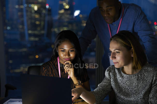 Geschäftsleute arbeiten spät am Laptop im Büro — Stockfoto