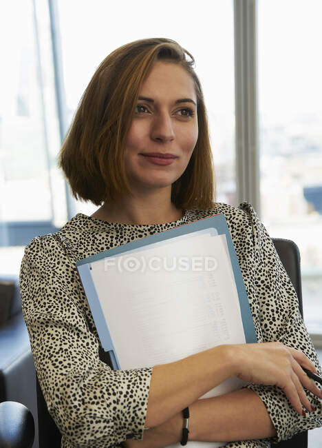 Portrait ambitious businesswoman with paperwork — Stock Photo
