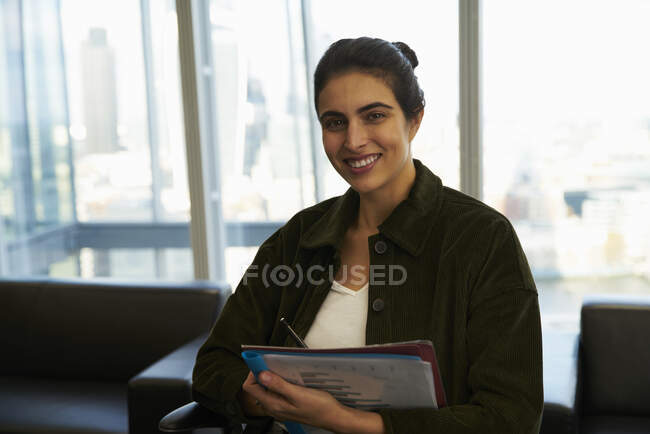 Portrait confident businesswoman with paperwork in office — Stock Photo