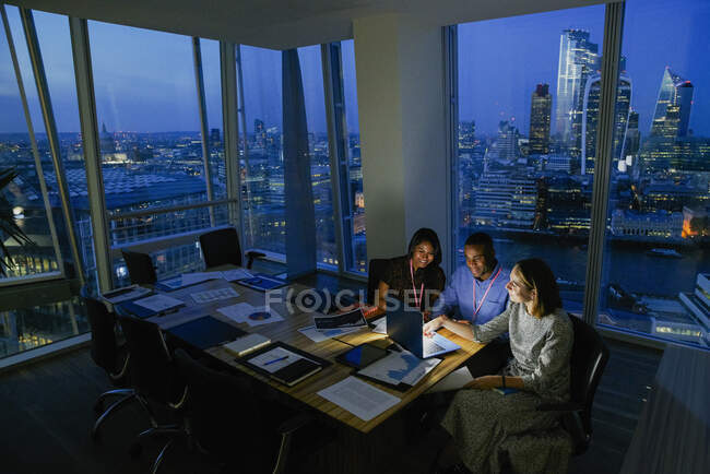 Gente de negocios que trabaja hasta tarde en Highrise Office, Londres, Reino Unido - foto de stock