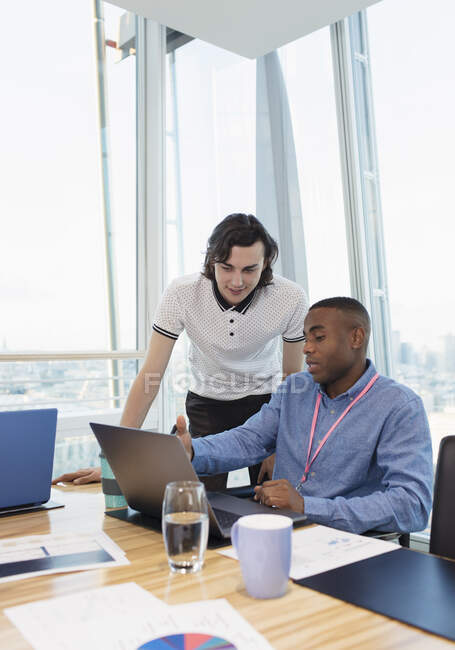 Businessmen working at laptop in conference room — Stock Photo