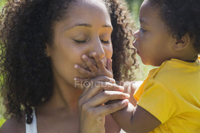 Nahaufnahme liebevolle Mutter küsst Hand von Kleinkind Tochter — Stockfoto